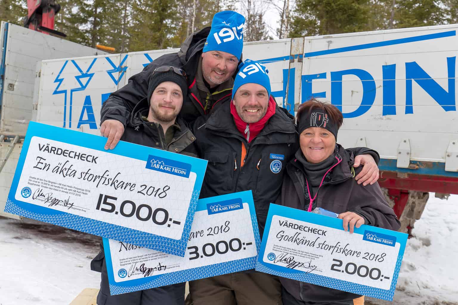 Martin Berggren-Lysell från tävlingens huvudsponsor Karl Hedin flankeras av segerpallen i Karl Hedin Pimpelcup 2018, från vänster tvåan Mikael Westlund, segraren Anders Axelsson samt längst till höger trean Maud Eriksson. Foto: Morgan Grip